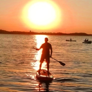 Stand-Up-Paddling ist eine tolle Möglichkeit, um sich fit zu halten. Dabei trainierst du nicht nur deine Standhaftigkeit und Balance, im weiteren Verlauf geht das Training auch deutlich auf Kraft und Ausdauer. Aber das tolle daran? Es liegt ganz an dir, in welcher Intensität du das Paddeln ausüben möchtest. Denn auch um einfach den Kopf frei zu bekommen und sich in der Natur zu entspannen, eignet sich das Stand-Up-Paddling perfekt. Du möchtest gerne etwas Neues ausprobieren oder dein Können weiter verbessern? Bei uns lernst du spielend einfach, wie du mit deinem Board und Paddel umgehst – vom Transport und Vorbereitung an Land bis zur Durchführung auf dem Wasser. Wir zeigen dir, wie man seine Balance auf dem Board hält und wie man am besten sein Paddel hält, um voran zu kommen. Zum Einstieg erklären wir Dir den richtigen Stand und die passende Paddeltechnik erst am Land, bevor es dann aufs Wasser geht. Außerdem zeigen wir Dir (wenn du willst) die schönsten Paddelorte Deutschlands und der Beneluxstaaten, und wie du diese vom Wasser aus genießen kannst. Also worauf wartest du noch? Bei uns könnt Ihr tolle Erfahrungen sammeln und den Spaß am Wassersport mit anderen Kursteilnehmern teilen. Wir freuen uns auf Dich! Die benötigten Materialien, welche sehr gut für Anfänger geeignet sind, stellen wir zur Verfügung (außer ihr habt bereits euer eigenes Board, dieses könnt Ihr natürlich gerne mitbringen). Durch das Erlernen der gängigen Fachbegriffe und der verschiedenen Fahrtechniken könnt Ihr gefahrlos den Paddelspaß auf dem Wasser genießen!