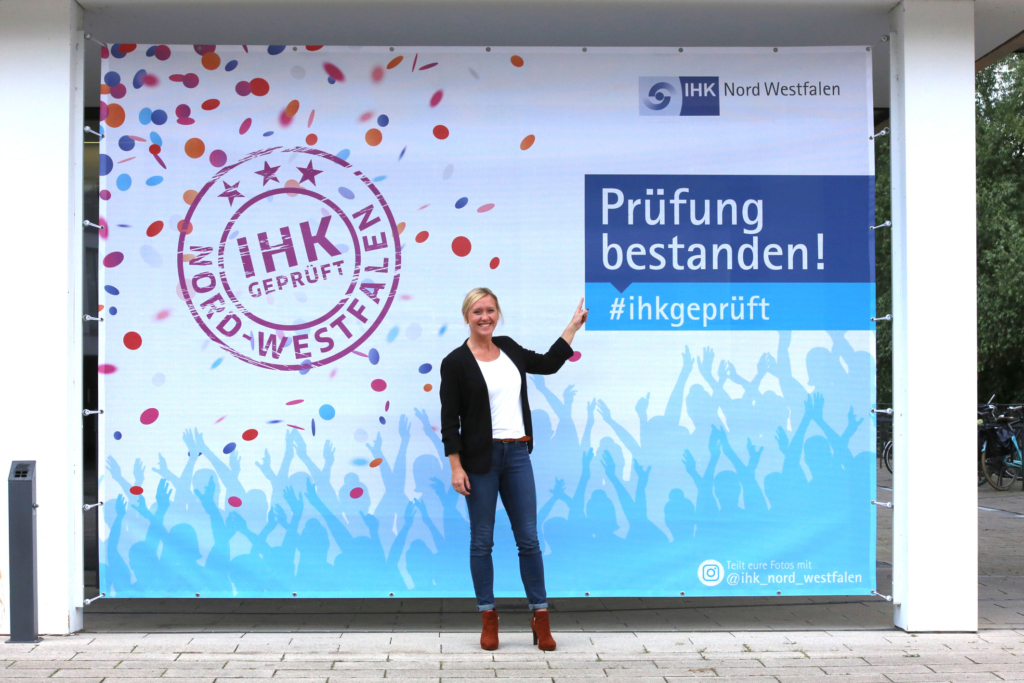 IHK-Vizepräsidentin Melanie Baum vor der Fotowand am IHK-Bildungszentrum in Münster.